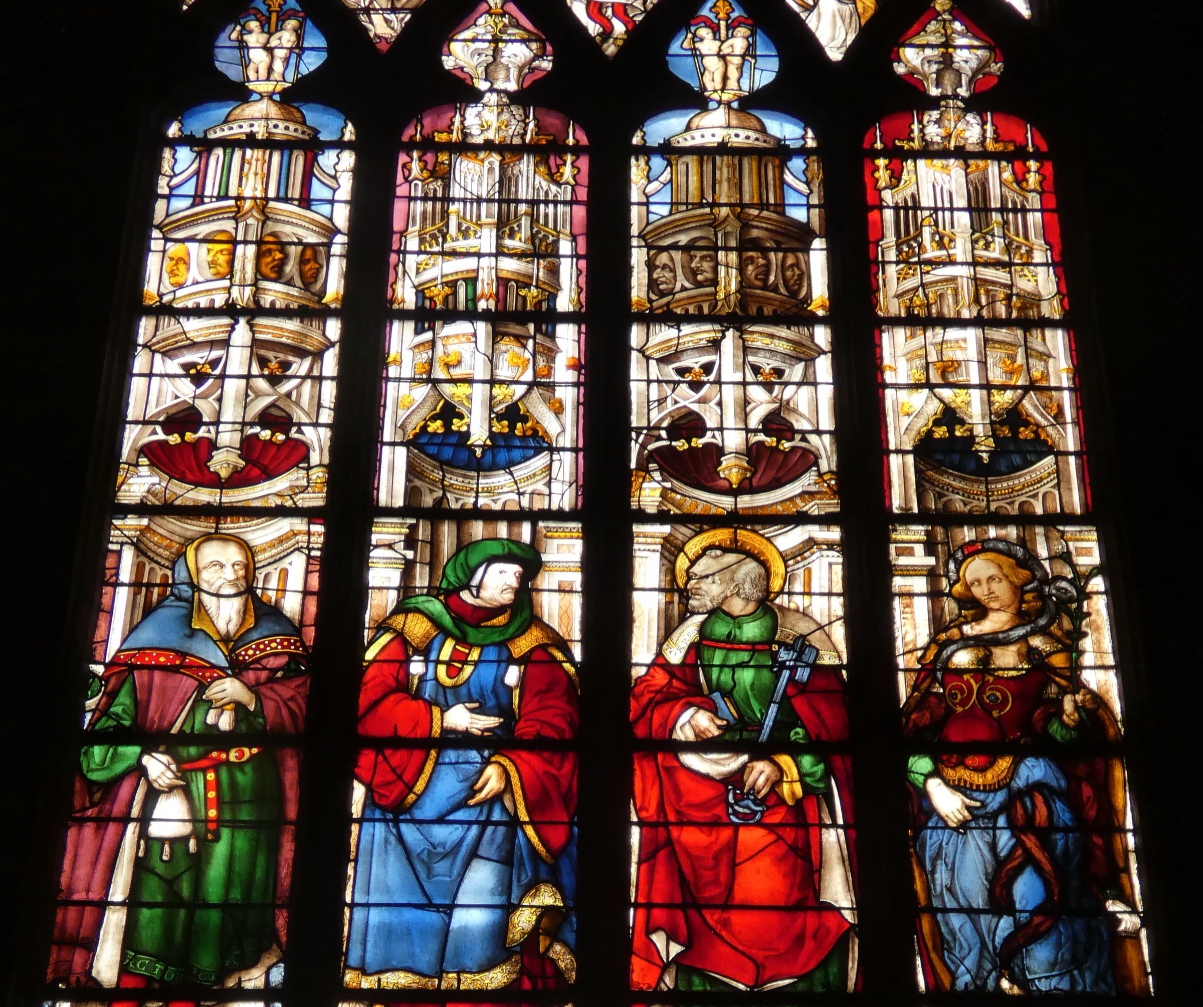 Renaissance stained glass at Auch cathedral, standing figures in scarlet, blue and green with gold haloes