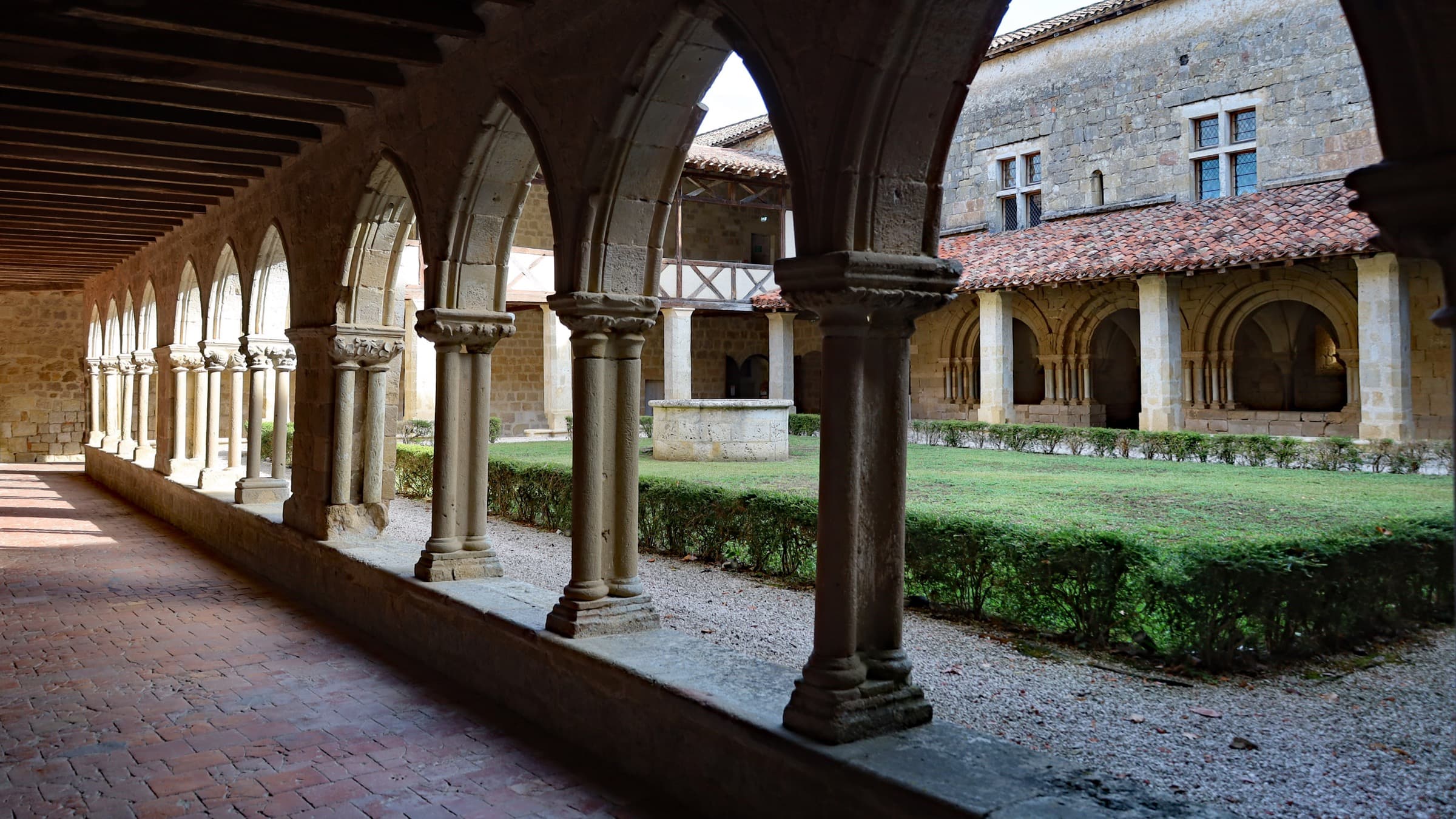 The Romanesque cloister gallery at Flaran, paired columns and rounded arches beside a lawn