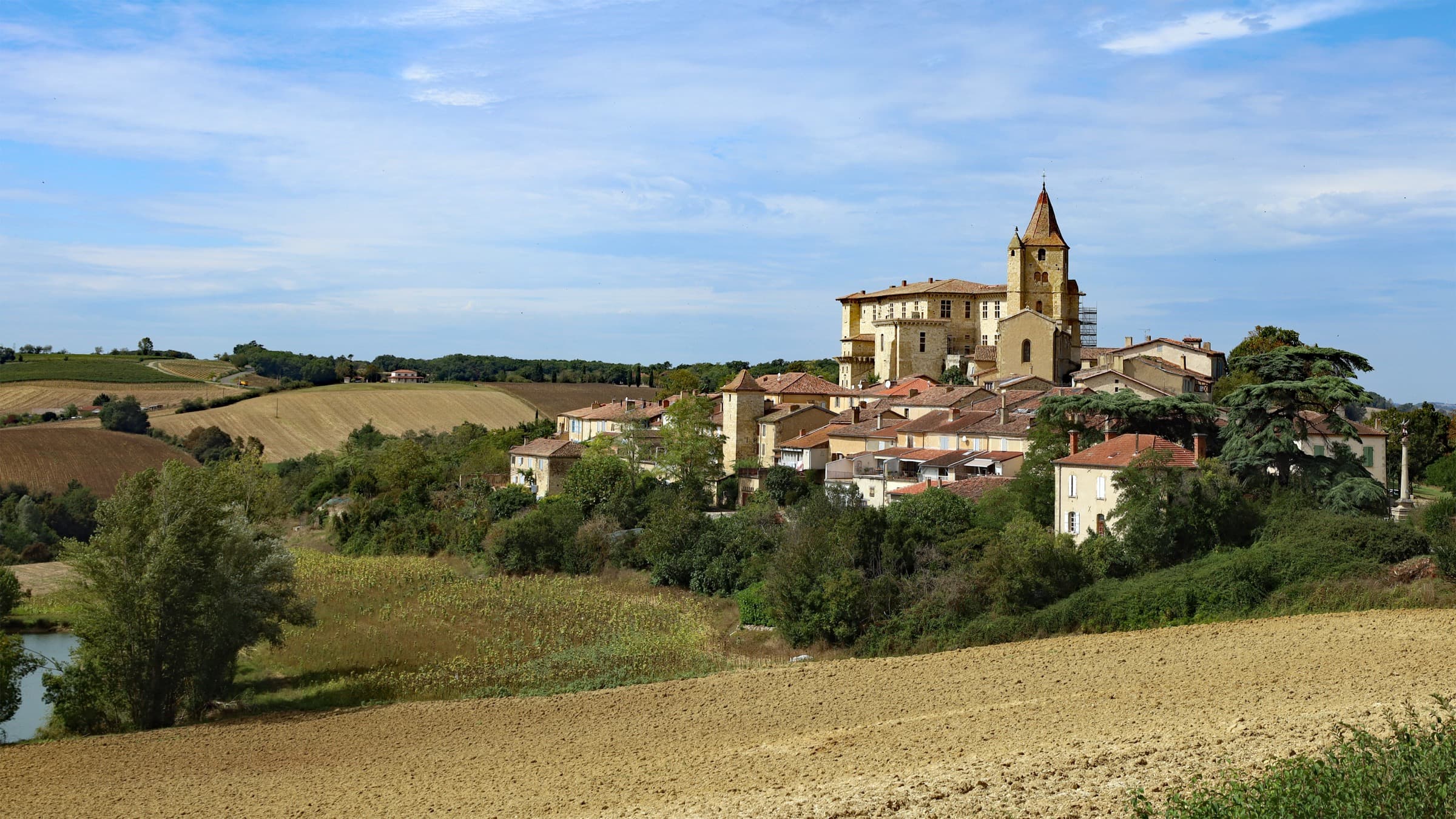 The village and château of Lavardens crowning a ridge above ploughed and green fields