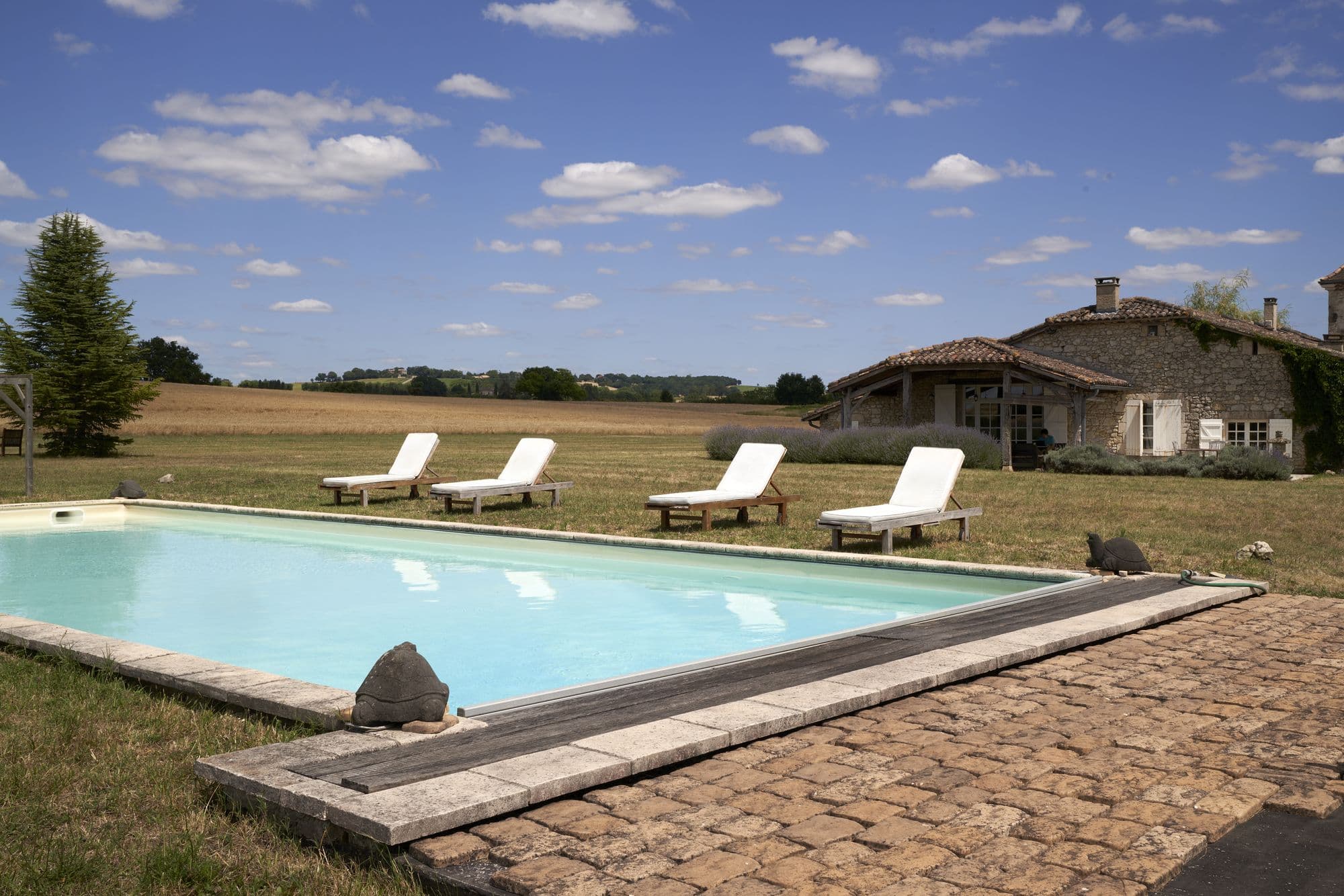 The pool with the house and its tower behind it
