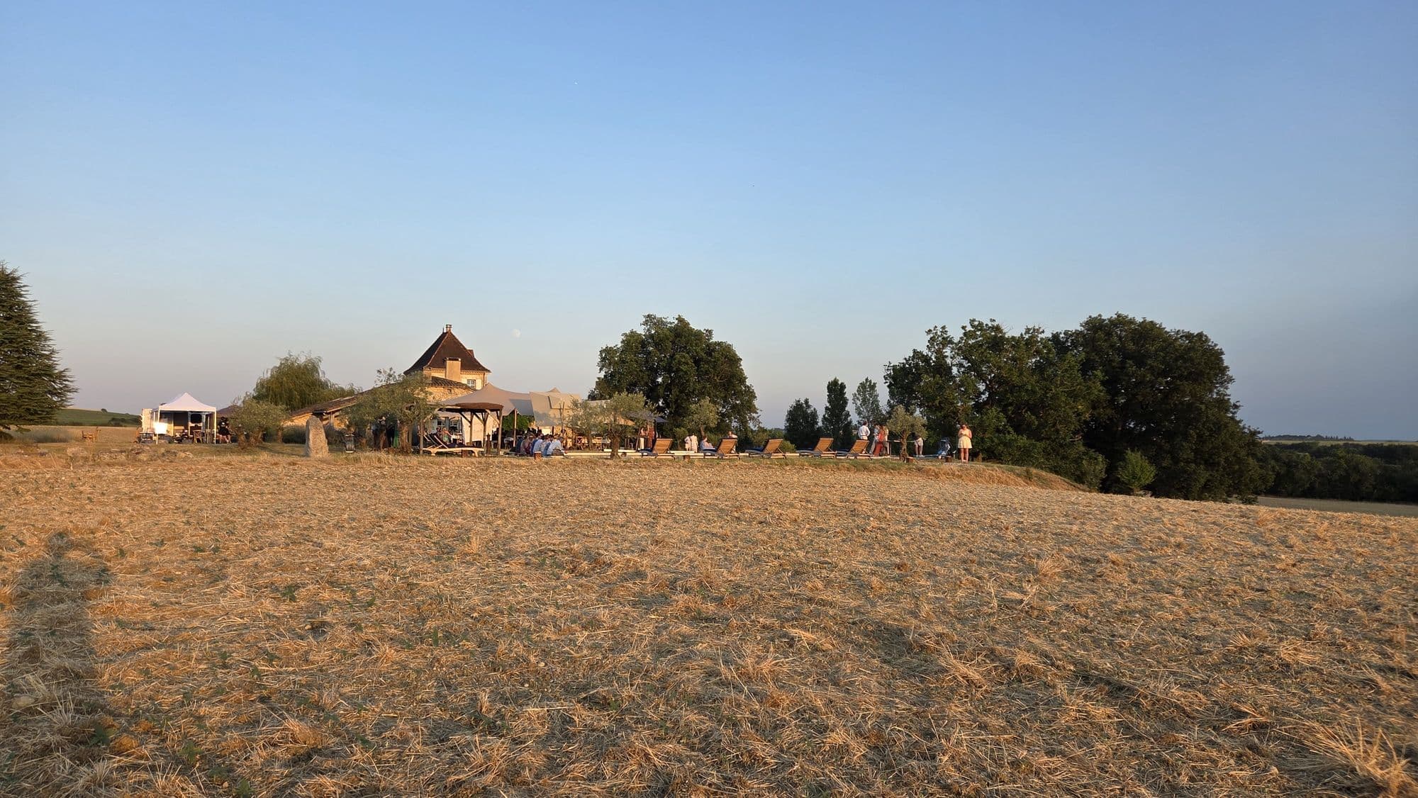 The house and marquee seen across the fields at dusk